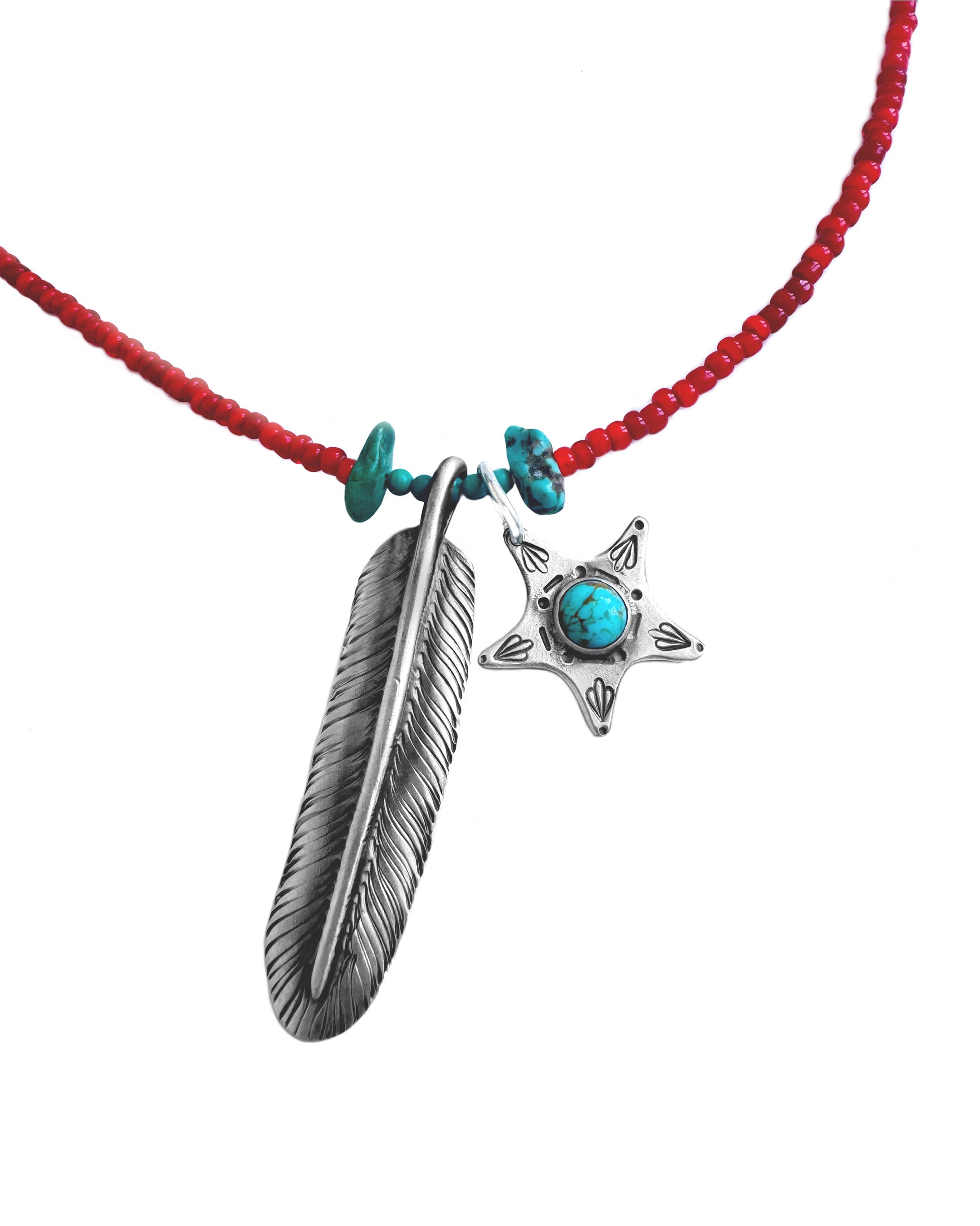 A red beaded necklace featuring a silver-toned feather pendant and a silver-toned five-pointed star pendant with a turquoise stone in the center, accented with small turquoise beads on the cord.